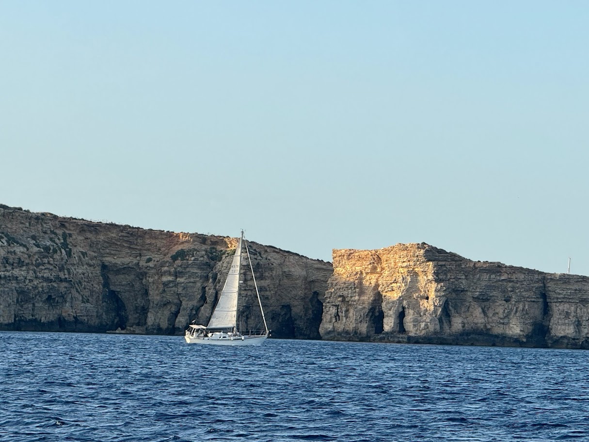 Sailing past the Gozo cliffs under mainsail.